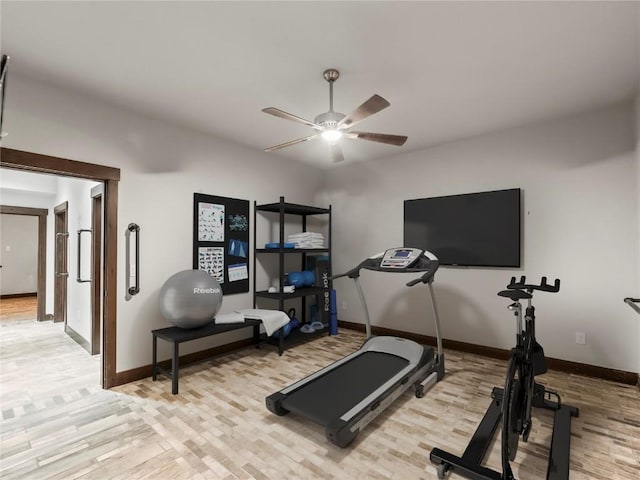 workout area with light wood-type flooring, a ceiling fan, and baseboards