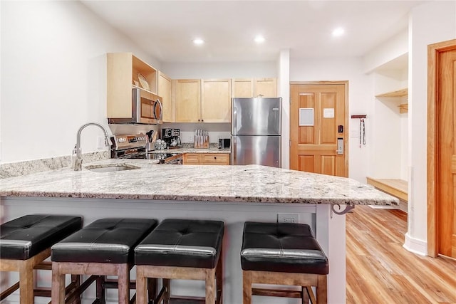 140 Ida Belle Dr Unit 8294, Dillon, CO 80435 - kitchen with stainless steel appliances, light brown cabinetry, a peninsula, light stone counters, and recessed lighting