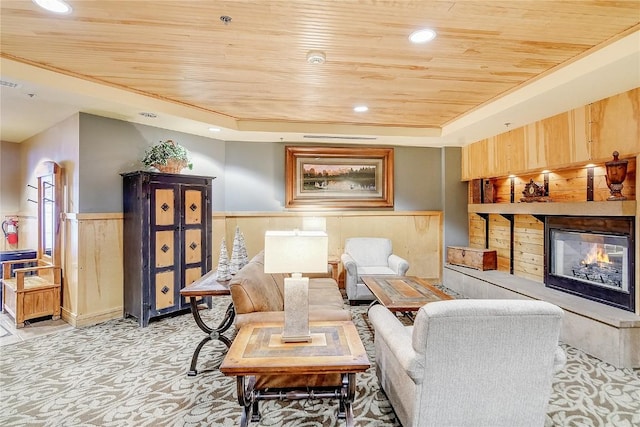 140 Ida Belle Dr Unit 8294, Dillon, CO 80435 - living room featuring wood ceiling, a wainscoted wall, a glass covered fireplace, light carpet, and a tray ceiling