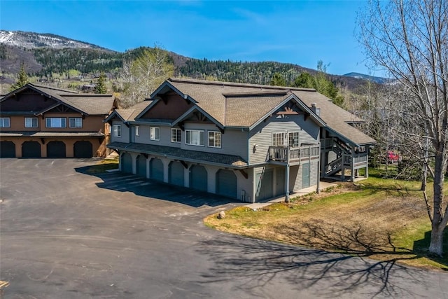view of front of property featuring an attached garage, a mountain view, and driveway