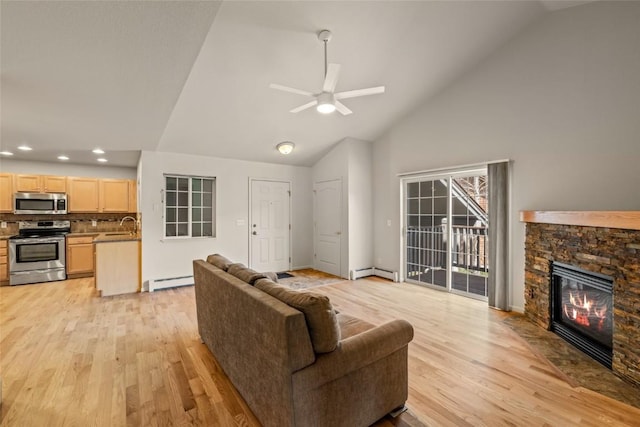 living area with light wood-type flooring, a baseboard heating unit, and high vaulted ceiling