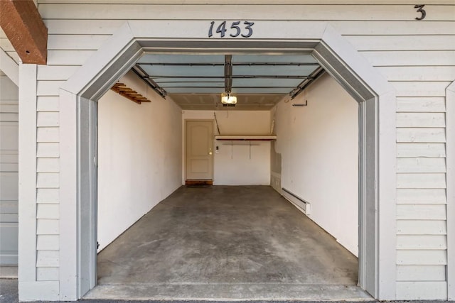 entrance to property with a garage and a baseboard radiator