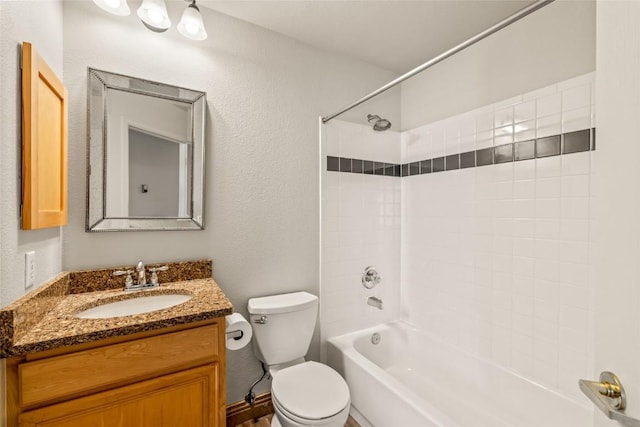 bathroom featuring toilet,  shower combination, vanity, and a textured wall