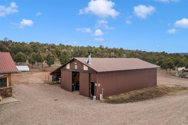 76 County Road 60b, Maybell, CO 81640 - view of home's exterior featuring metal roof, an outbuilding, and a view of trees