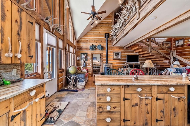 76 County Road 60b, Maybell, CO 81640 - kitchen with stone tile floors, a wood stove, a towering ceiling, a ceiling fan, and open floor plan