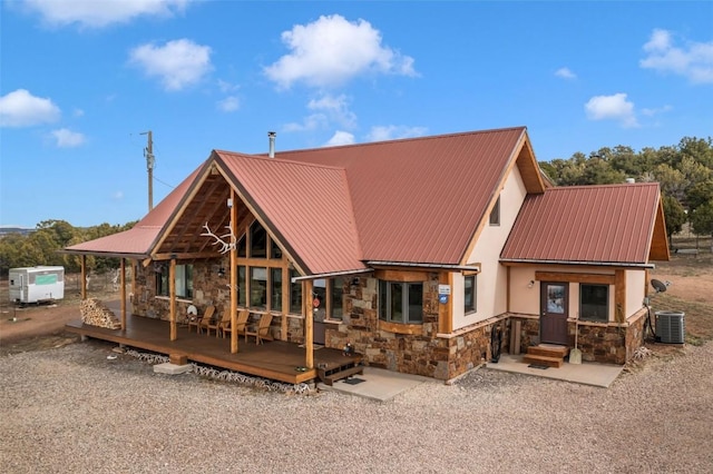 76 County Road 60b, Maybell, CO 81640 - rear view of property featuring stone siding, cooling unit, a wooden deck, stucco siding, and metal roof