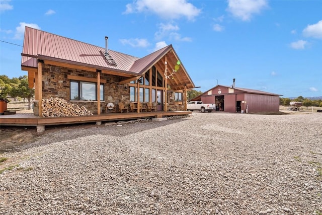 76 County Road 60b, Maybell, CO 81640 - back of house featuring stone siding, a wooden deck, metal roof, and an outdoor structure