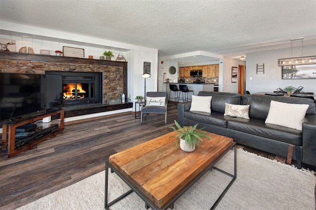 21620 US Highway 6 Unit 2152, Keystone, CO 80435 - living room featuring wood finished floors, a fireplace, and a textured ceiling