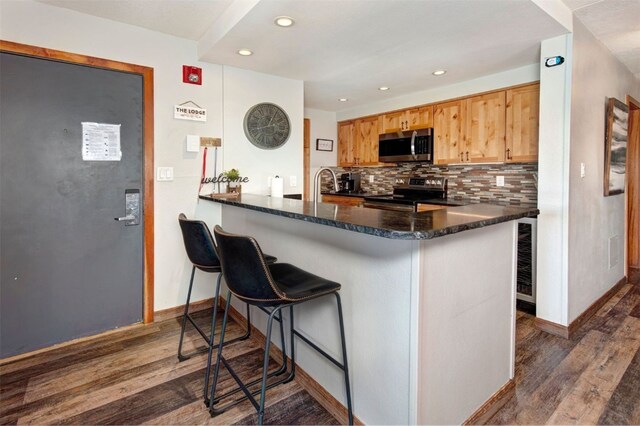 21620 US Highway 6 Unit 2152, Keystone, CO 80435 - kitchen with appliances with stainless steel finishes, dark wood-type flooring, decorative backsplash, baseboards, and recessed lighting
