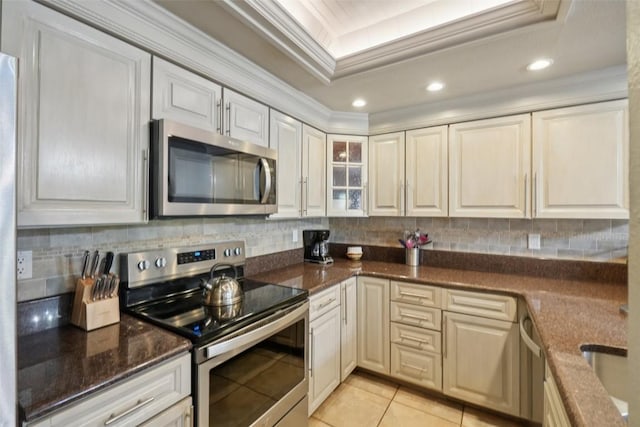 720 Columbine Rd Unit 303, Breckenridge, CO 80424 - kitchen featuring appliances with stainless steel finishes, crown molding, a tray ceiling, tasteful backsplash, and dark stone countertops