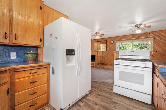 186 E Jefferson Ave, Hayden, CO 81639 - kitchen with white appliances, ceiling fan, wood walls, wood finished floors, and brown cabinets