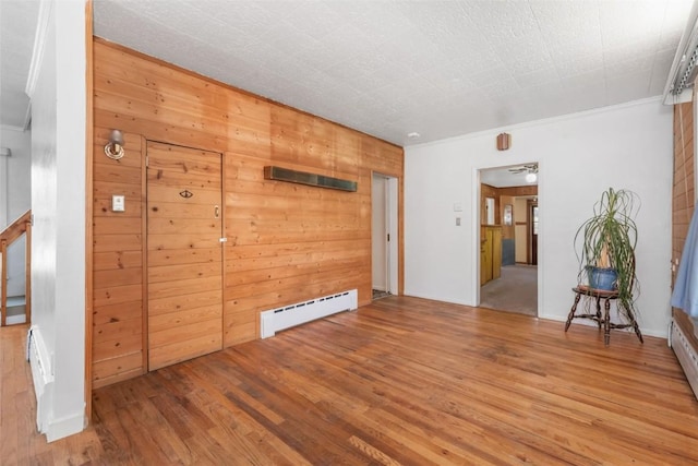 186 E Jefferson Ave, Hayden, CO 81639 - unfurnished room with wood finished floors, a baseboard heating unit, crown molding, and wooden walls
