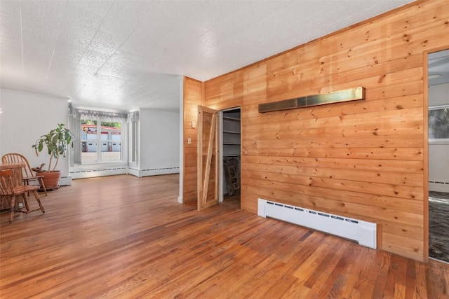 186 E Jefferson Ave, Hayden, CO 81639 - living area featuring a baseboard radiator, wood finished floors, and wooden walls