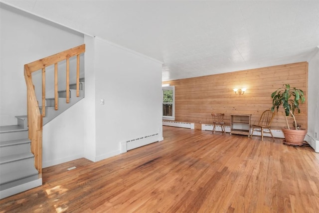 186 E Jefferson Ave, Hayden, CO 81639 - unfurnished living room featuring wood finished floors, wooden walls, stairway, and a baseboard heating unit