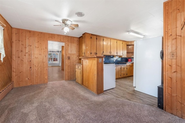 186 E Jefferson Ave, Hayden, CO 81639 - kitchen with a ceiling fan, light colored carpet, freestanding refrigerator, wooden walls, and range