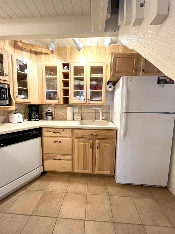 1920 Ski Time Square Dr Unit 208, Steamboat Springs, CO 80487 - kitchen with white appliances, light countertops, backsplash, light brown cabinets, and light tile patterned flooring