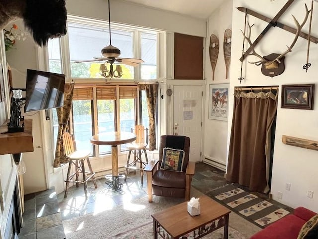 1920 Ski Time Square Dr Unit 208, Steamboat Springs, CO 80487 - living area featuring a baseboard heating unit and a ceiling fan