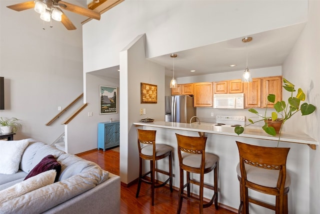 700 Lakepoint Dr Unit A10, Frisco, CO 80443 - kitchen featuring a breakfast bar, white appliances, open floor plan, and dark wood-type flooring