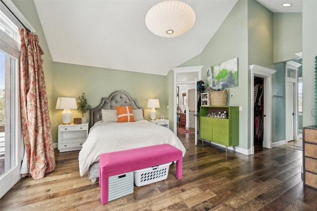 bedroom featuring high vaulted ceiling, multiple windows, baseboards, and wood finished floors