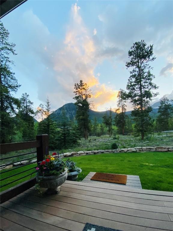 wooden terrace with a mountain view and a yard