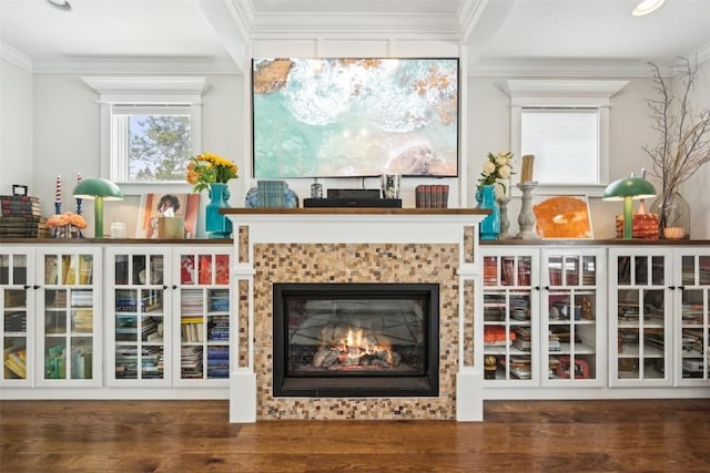 sitting room featuring crown molding, plenty of natural light, wood finished floors, and a tile fireplace