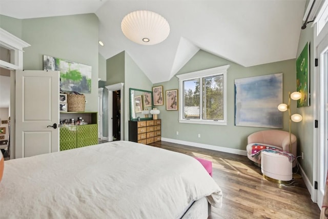 bedroom with baseboards, wood finished floors, and lofted ceiling