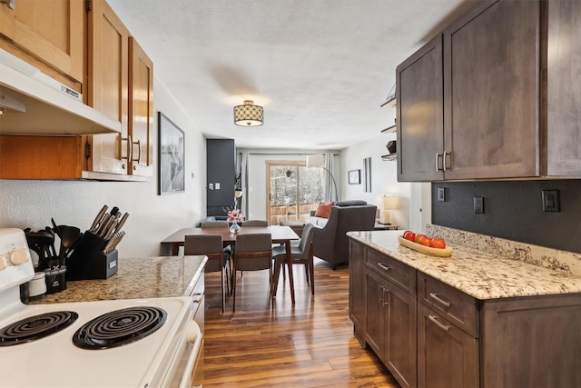 22974 US Highway 6 Unit A102, Keystone, CO 80435 - kitchen featuring white electric stove, extractor fan, dark wood-style floors, open floor plan, and dark brown cabinetry