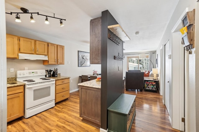 22974 US Highway 6 Unit A102, Keystone, CO 80435 - kitchen with white electric range, under cabinet range hood, light wood-style floors, and light stone countertops