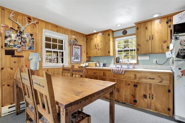 823 Gcr 8411, Tabernash, CO 80478 - kitchen with a baseboard heating unit, light countertops, wood walls, brown cabinets, and ornamental molding