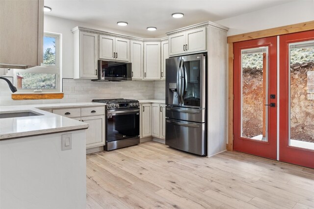 3415 Redhill Rd, Fairplay, CO 80440 - kitchen featuring stainless steel appliances, a sink, french doors, decorative backsplash, and light stone counters