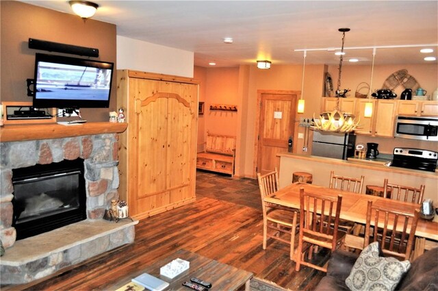 91 River Run Rd Unit 8122, Keystone, CO 80435 - living room featuring dark wood-type flooring, a stone fireplace, a chandelier, and recessed lighting