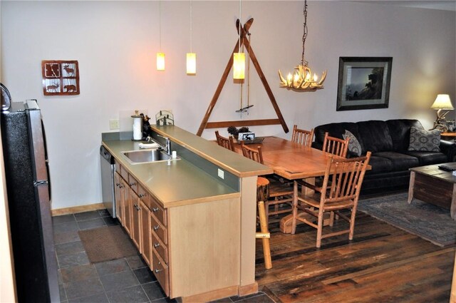 91 River Run Rd Unit 8122, Keystone, CO 80435 - kitchen featuring a sink, a peninsula, freestanding refrigerator, stainless steel dishwasher, and a chandelier