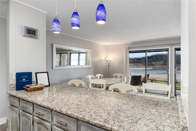 72 Corinthian Cir Unit 102, Dillon, CO 80435 - kitchen featuring a textured ceiling, a water view, hanging light fixtures, and light stone counters