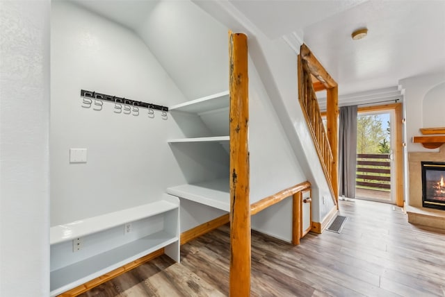 80 Cove Blvd Unit 103, Dillon, CO 80435 - stairs featuring wood finished floors, a glass covered fireplace, vaulted ceiling, and baseboards