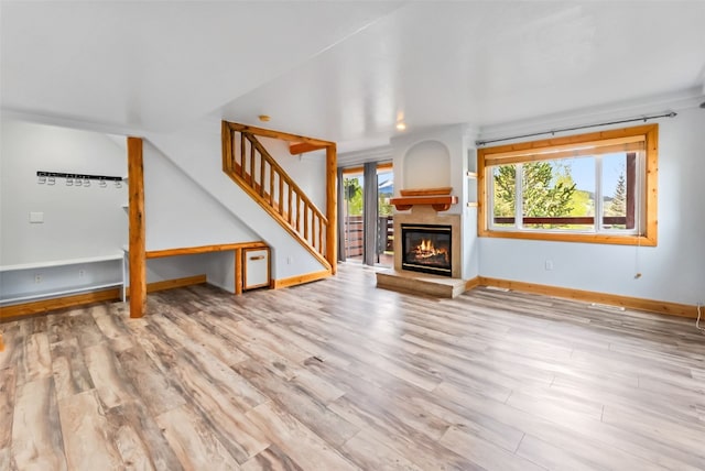 80 Cove Blvd Unit 103, Dillon, CO 80435 - unfurnished living room featuring wood finished floors, stairs, baseboards, and a glass covered fireplace
