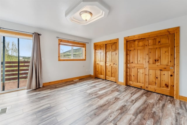 80 Cove Blvd Unit 103, Dillon, CO 80435 - unfurnished bedroom with access to outside, wood finished floors, baseboards, and two closets