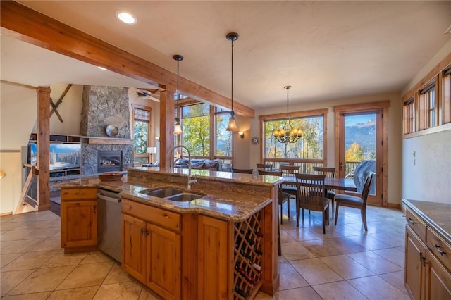 2206 Hamilton Creek Rd, Silverthorne, CO 80498 - kitchen with stainless steel dishwasher, open floor plan, a fireplace, light tile patterned floors, and dark stone countertops