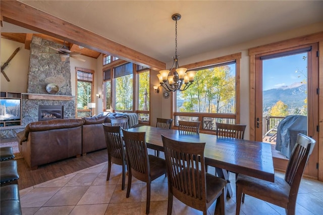 2206 Hamilton Creek Rd, Silverthorne, CO 80498 - dining room with a chandelier, light tile patterned floors, beamed ceiling, a fireplace, and ceiling fan