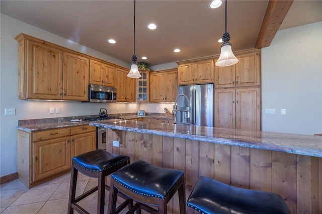 2206 Hamilton Creek Rd, Silverthorne, CO 80498 - kitchen with appliances with stainless steel finishes, dark stone counters, recessed lighting, a breakfast bar, and glass insert cabinets