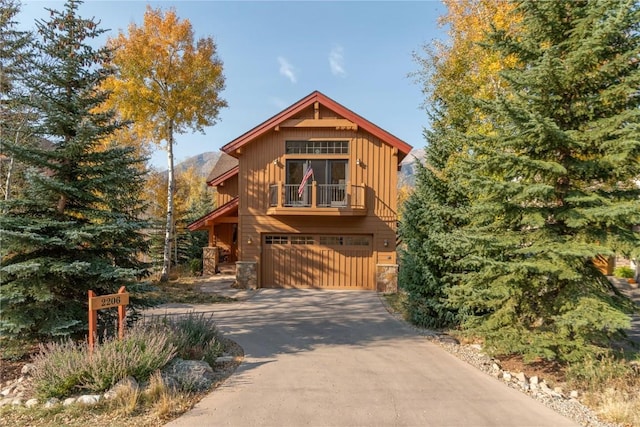 2206 Hamilton Creek Rd, Silverthorne, CO 80498 - chalet / cabin featuring a balcony, stone siding, driveway, and an attached garage