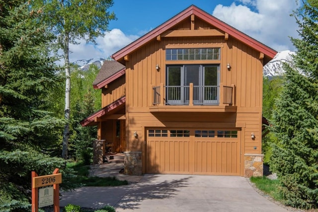 2206 Hamilton Creek Rd, Silverthorne, CO 80498 - chalet / cabin with a balcony, board and batten siding, a garage, concrete driveway, and stone siding