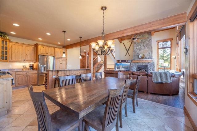 2206 Hamilton Creek Rd, Silverthorne, CO 80498 - dining space featuring a chandelier, recessed lighting, ceiling fan, a stone fireplace, and light tile patterned floors