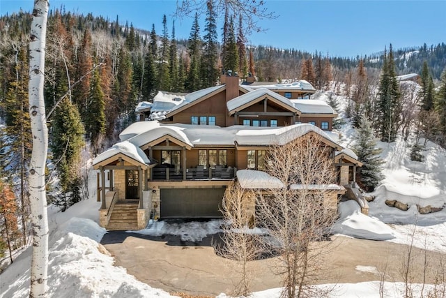 chalet / cabin with a garage and a view of trees