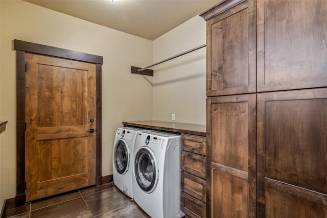 laundry area with cabinet space, dark tile patterned flooring, and washing machine and clothes dryer