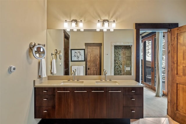 full bath with a stall shower, tile patterned flooring, a sink, and double vanity