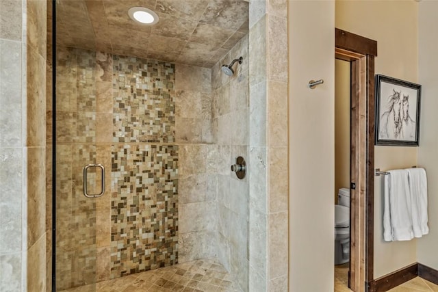 bathroom featuring a shower stall and toilet