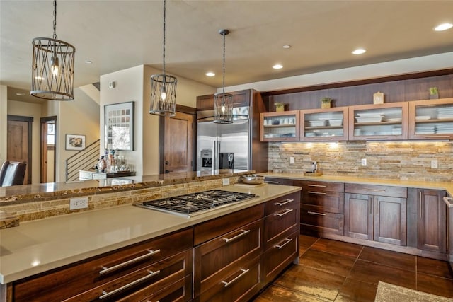 kitchen featuring light countertops, appliances with stainless steel finishes, backsplash, and glass insert cabinets