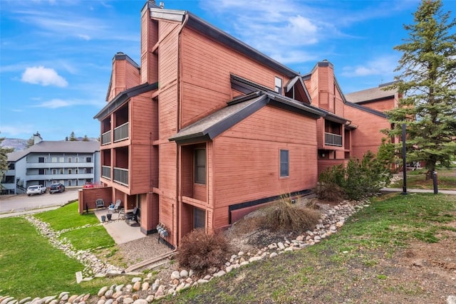 2015 Walton Creek Rd Unit 114, Steamboat Springs, CO 80487 - view of side of home featuring a lawn and a chimney