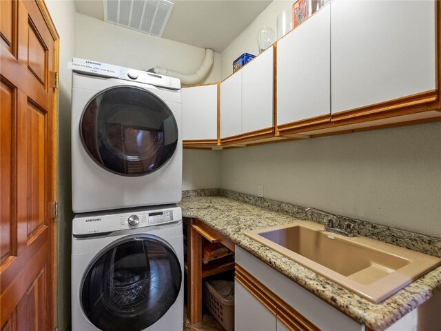 463 Blue Flag Cir, Breckenridge, CO 80424 - laundry room featuring stacked washer / drying machine and cabinet space