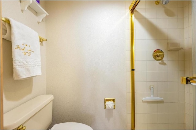 bathroom with toilet and tiled shower